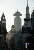 A city street with tall buildings and a clock tower