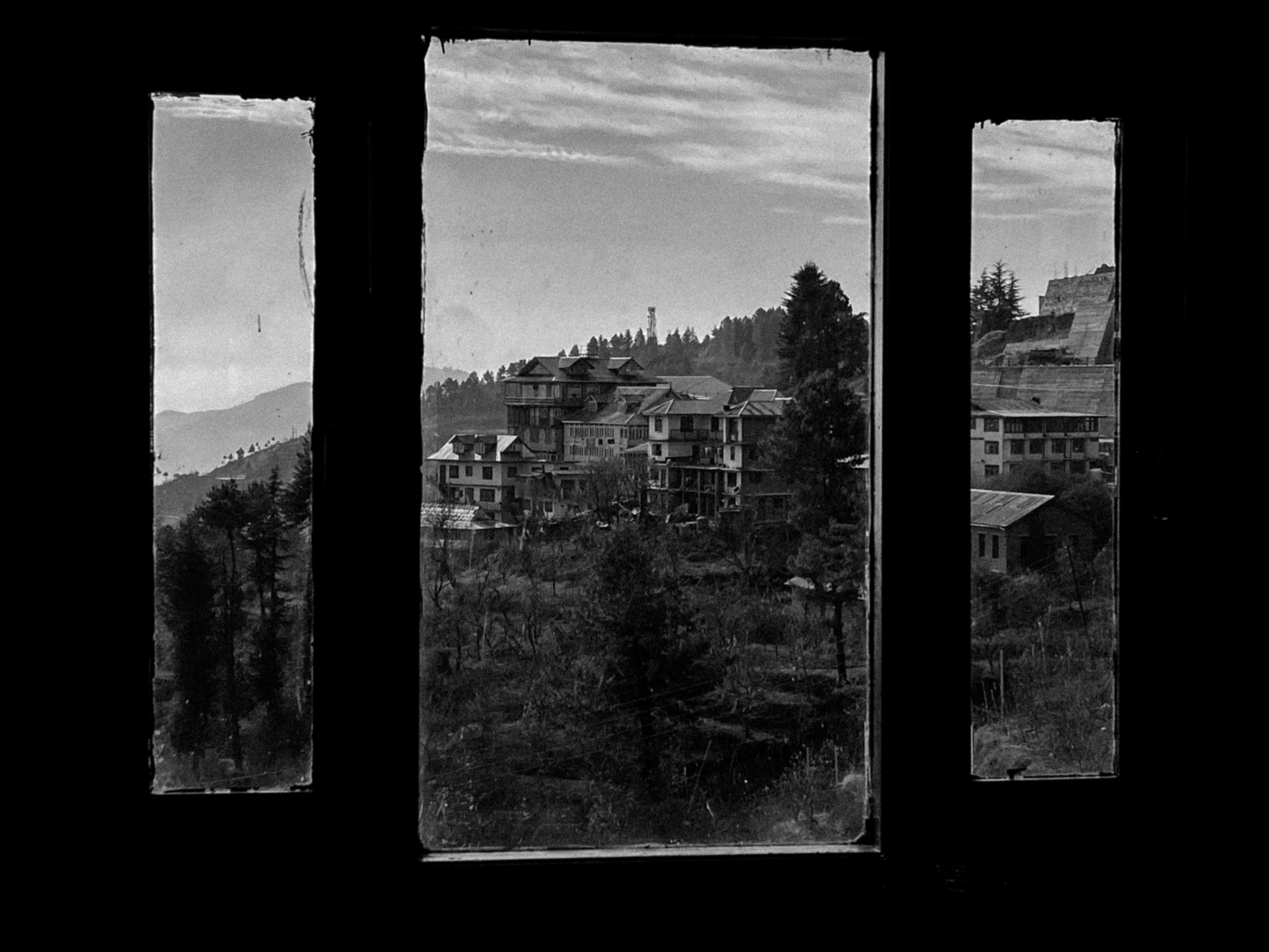 A black and white photo of a city seen through a window