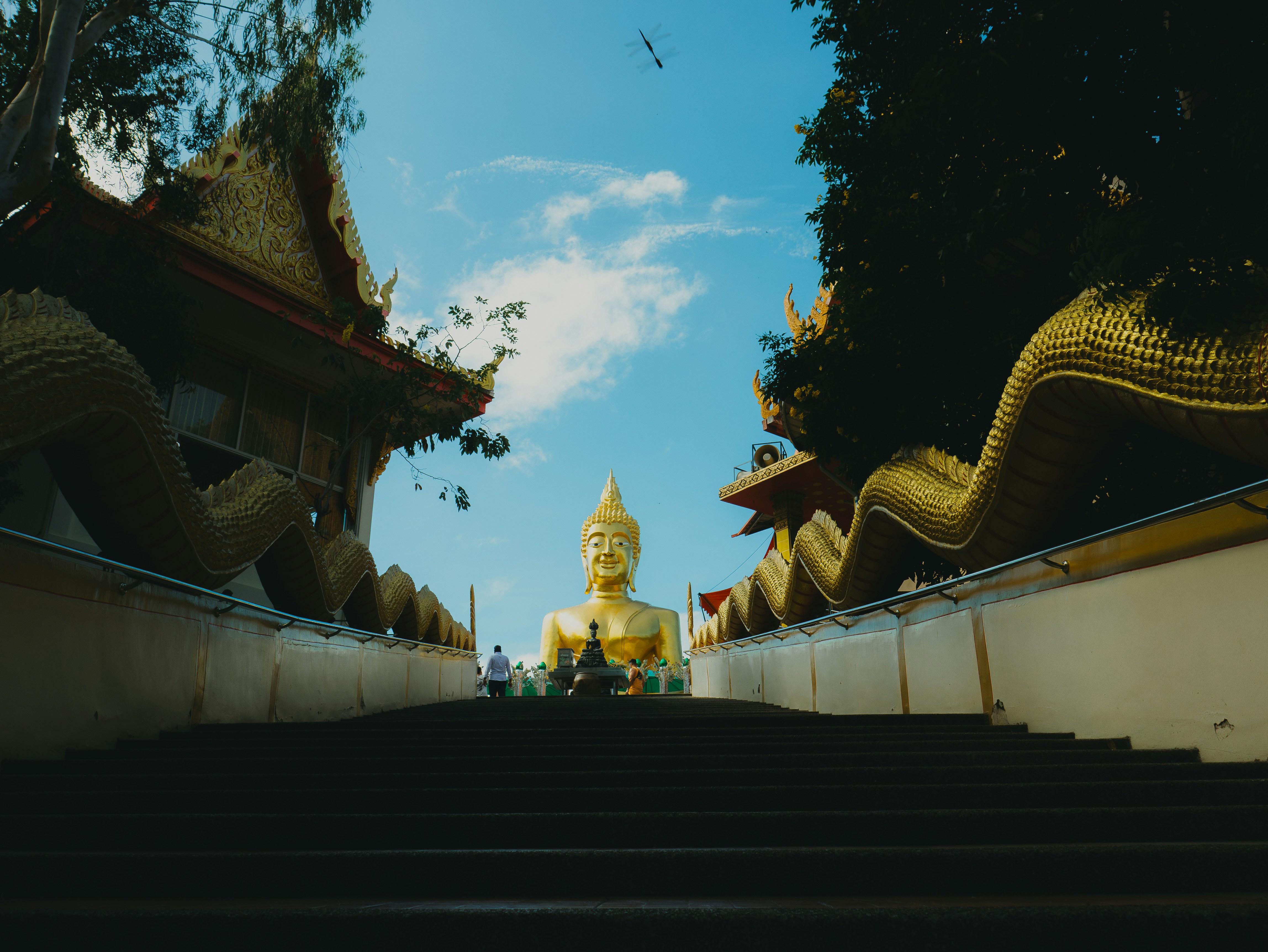 A large buddha statue sitting on top of a set of stairs