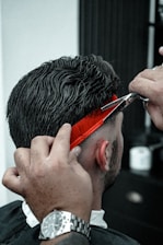 A man cutting another mans hair with a pair of scissors