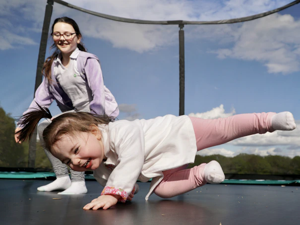 A little girl is playing on a trampoline