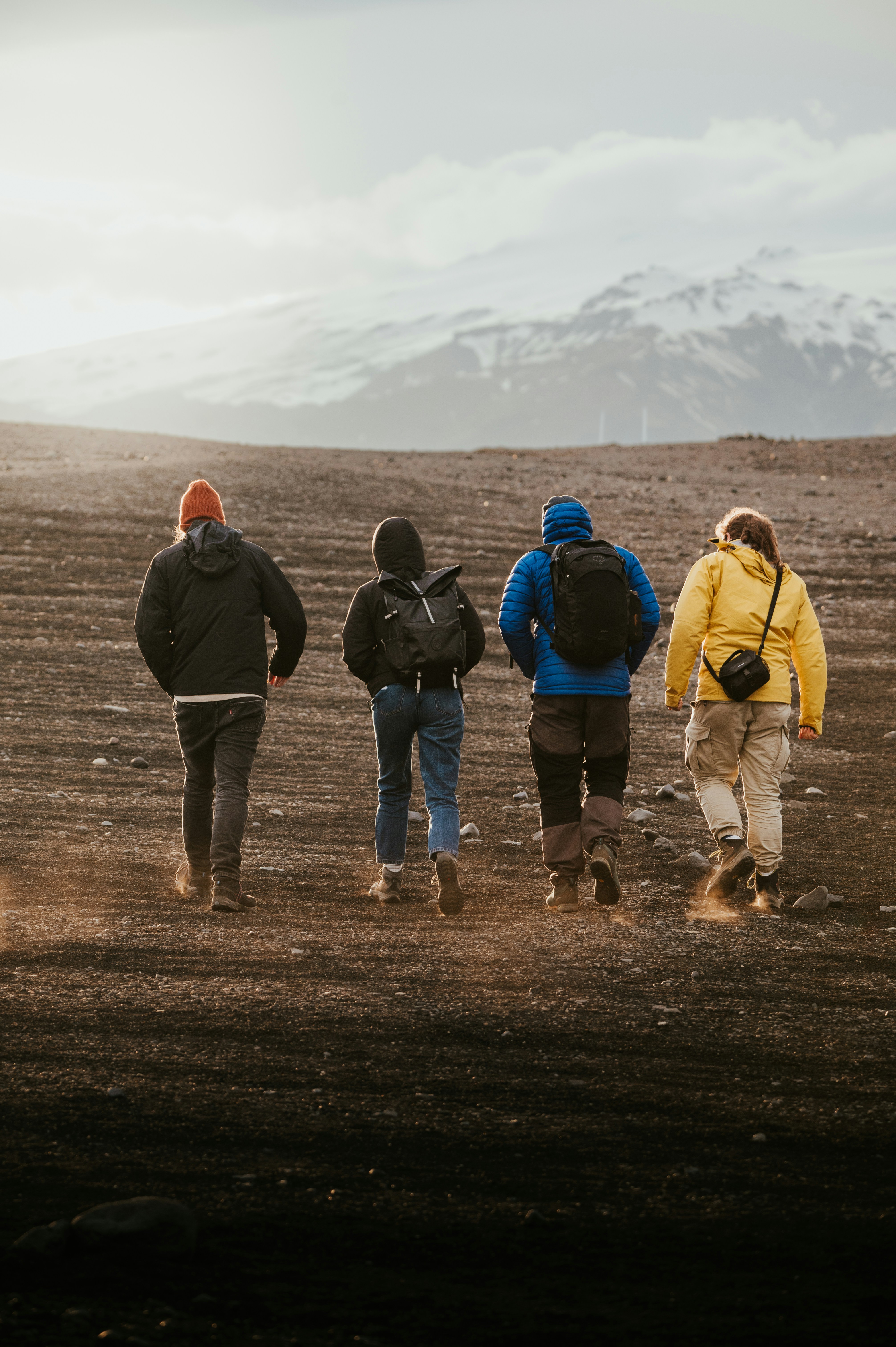 A group of people walking across a dirt field