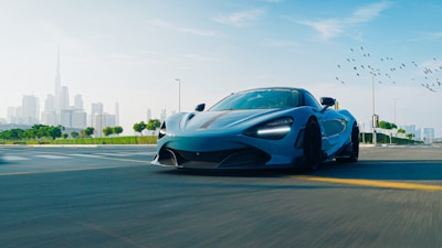 A blue sports car driving down a street