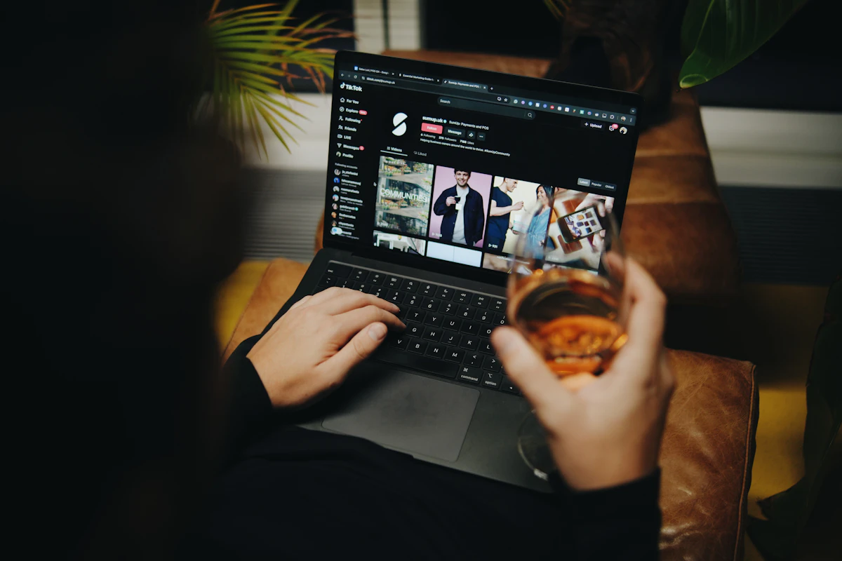 A person sitting on a couch with a laptop