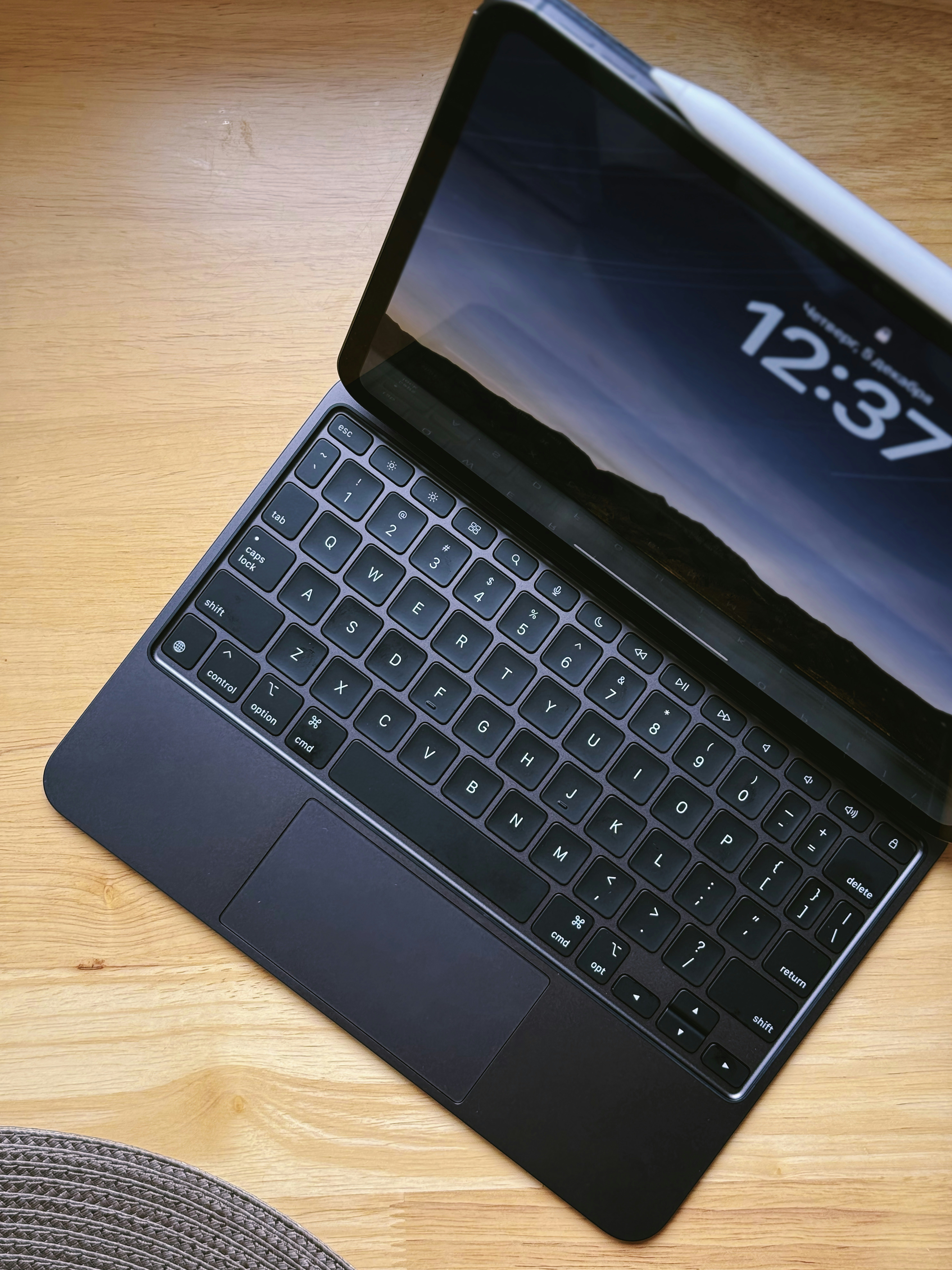 Tablet device with stylus on a light wooden surface, bright natural lighting