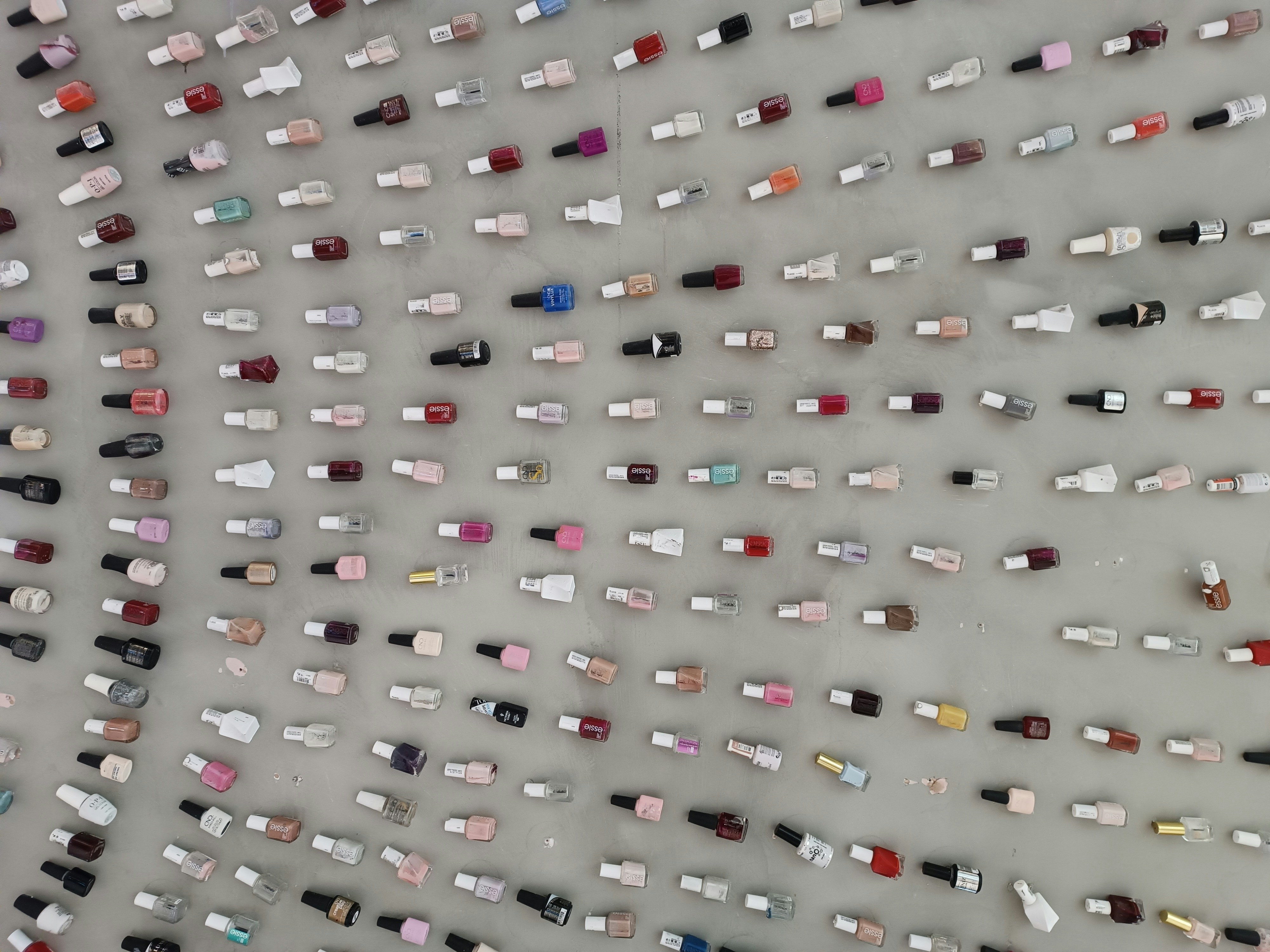 Collection of nail polish bottles in various shades arranged neatly