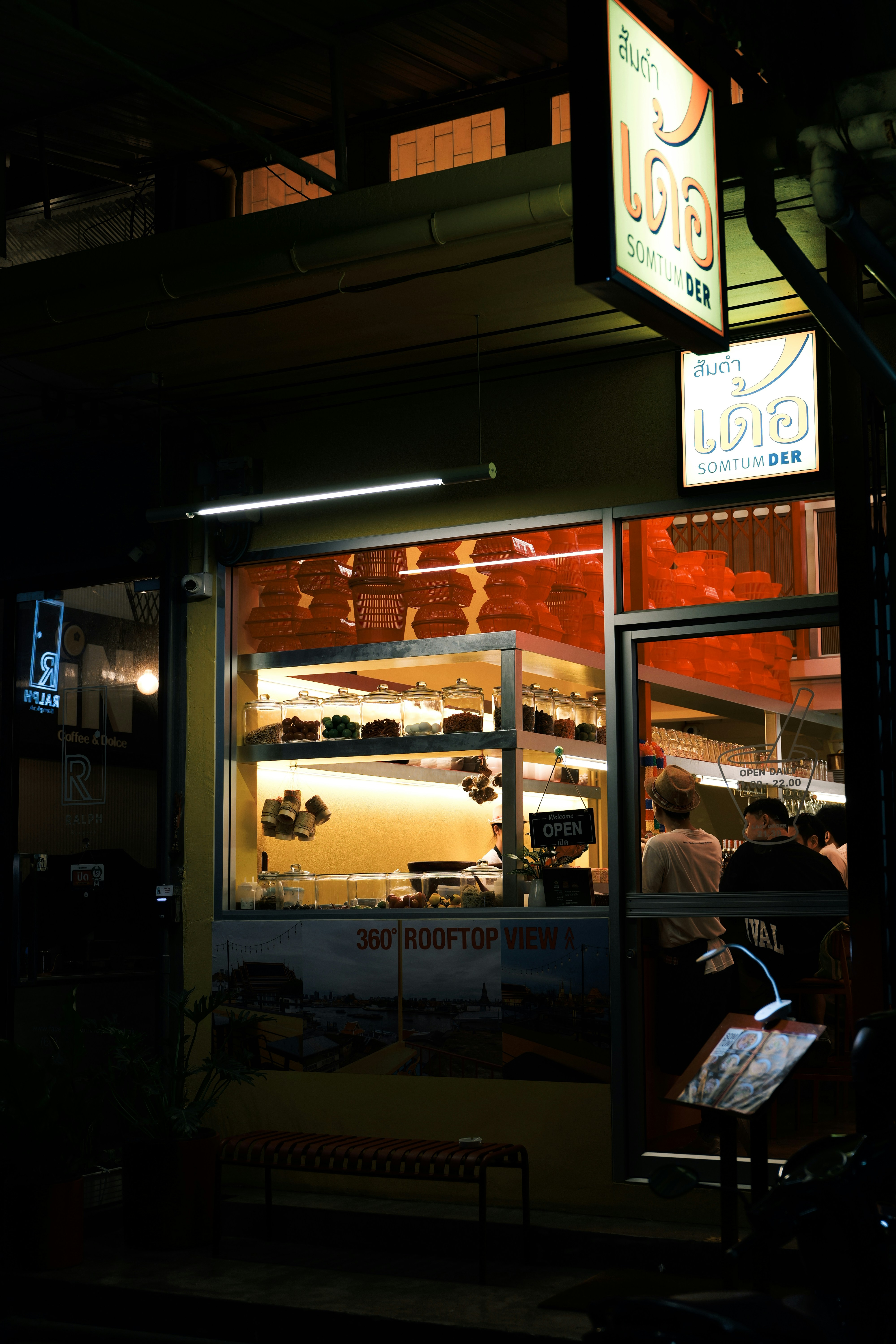 A restaurant at night with a lit up sign