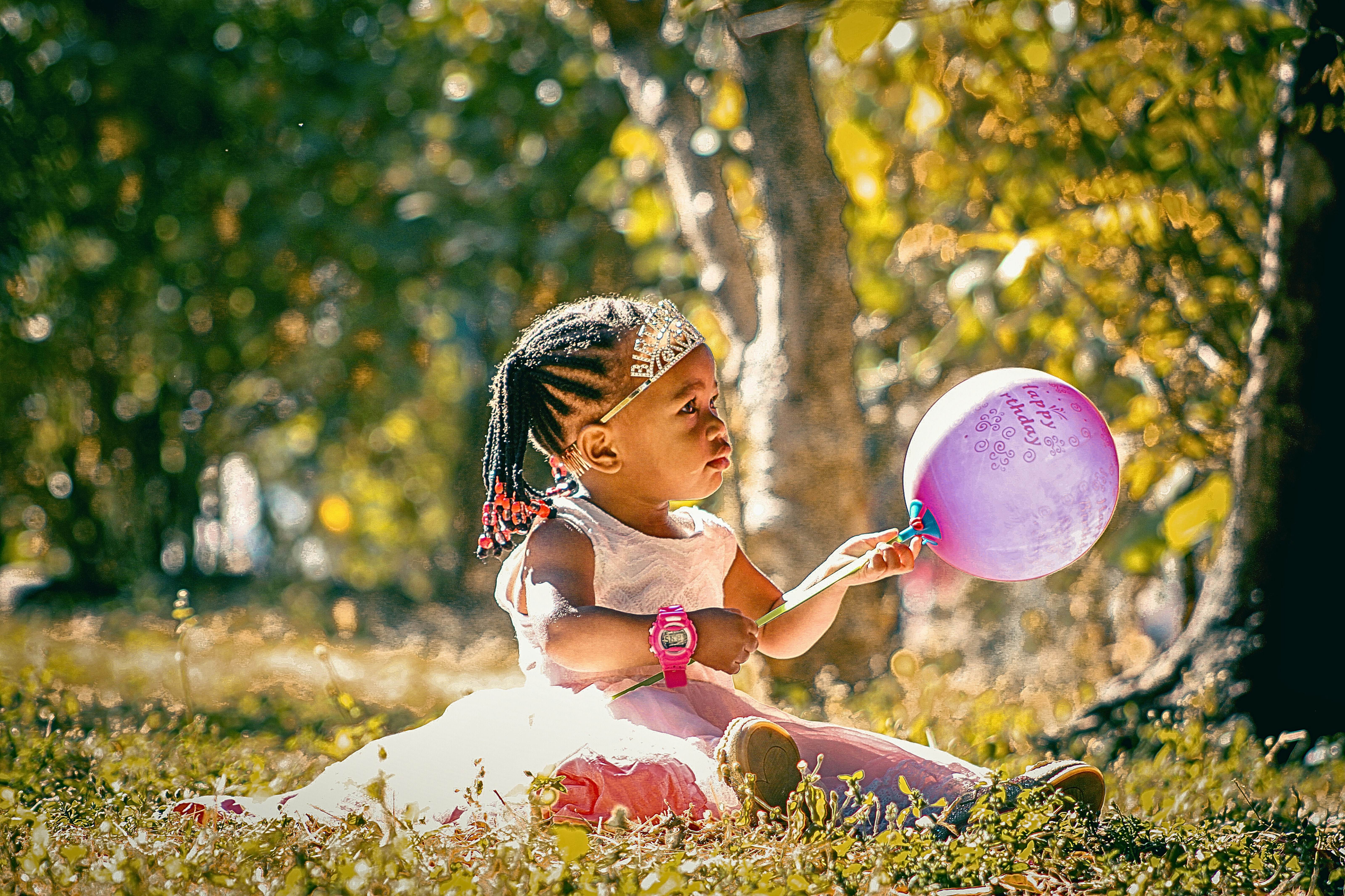 A little girl sitting in the grass with a frisbee