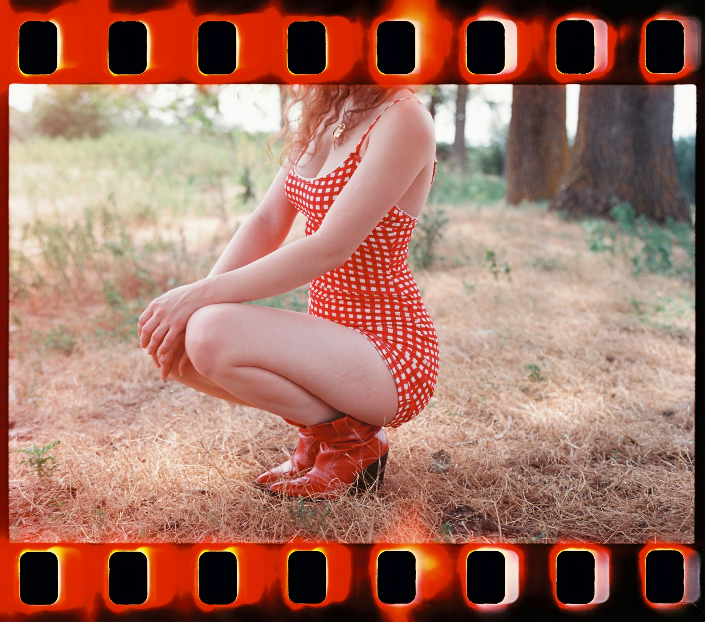 A woman sitting on the ground in a red and white dress