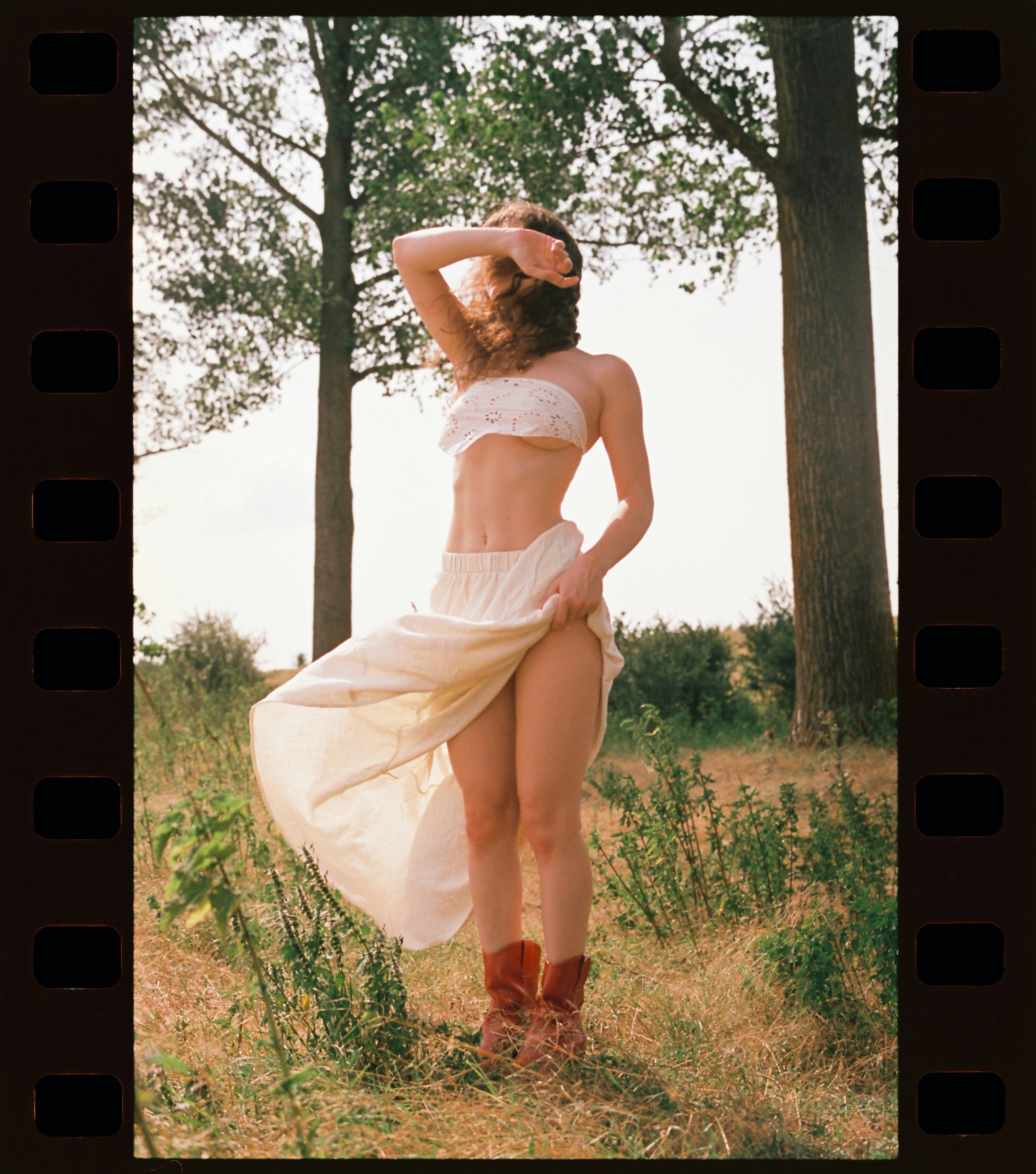 A woman in a white dress standing in a field