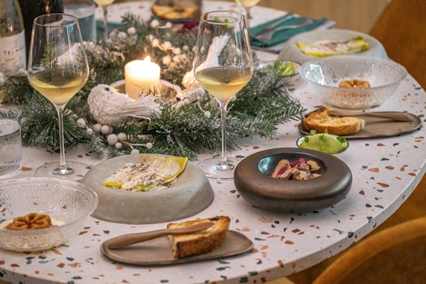 A table topped with plates of food and glasses of wine