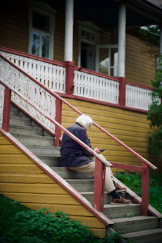 A woman sitting on the steps of a house