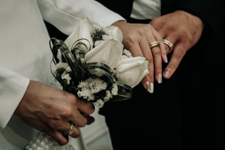 A close up of a person holding a bouquet of flowers