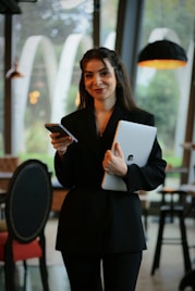 A woman standing in a restaurant holding a tablet