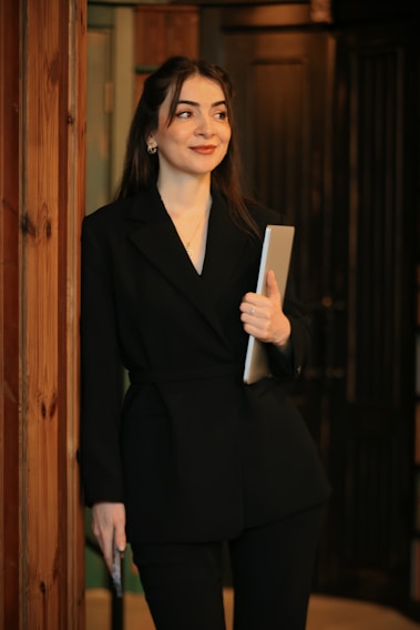 A woman in a black suit holding a folder
