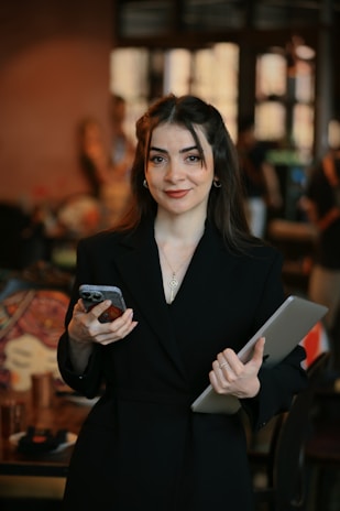 A woman in a black suit holding a tablet
