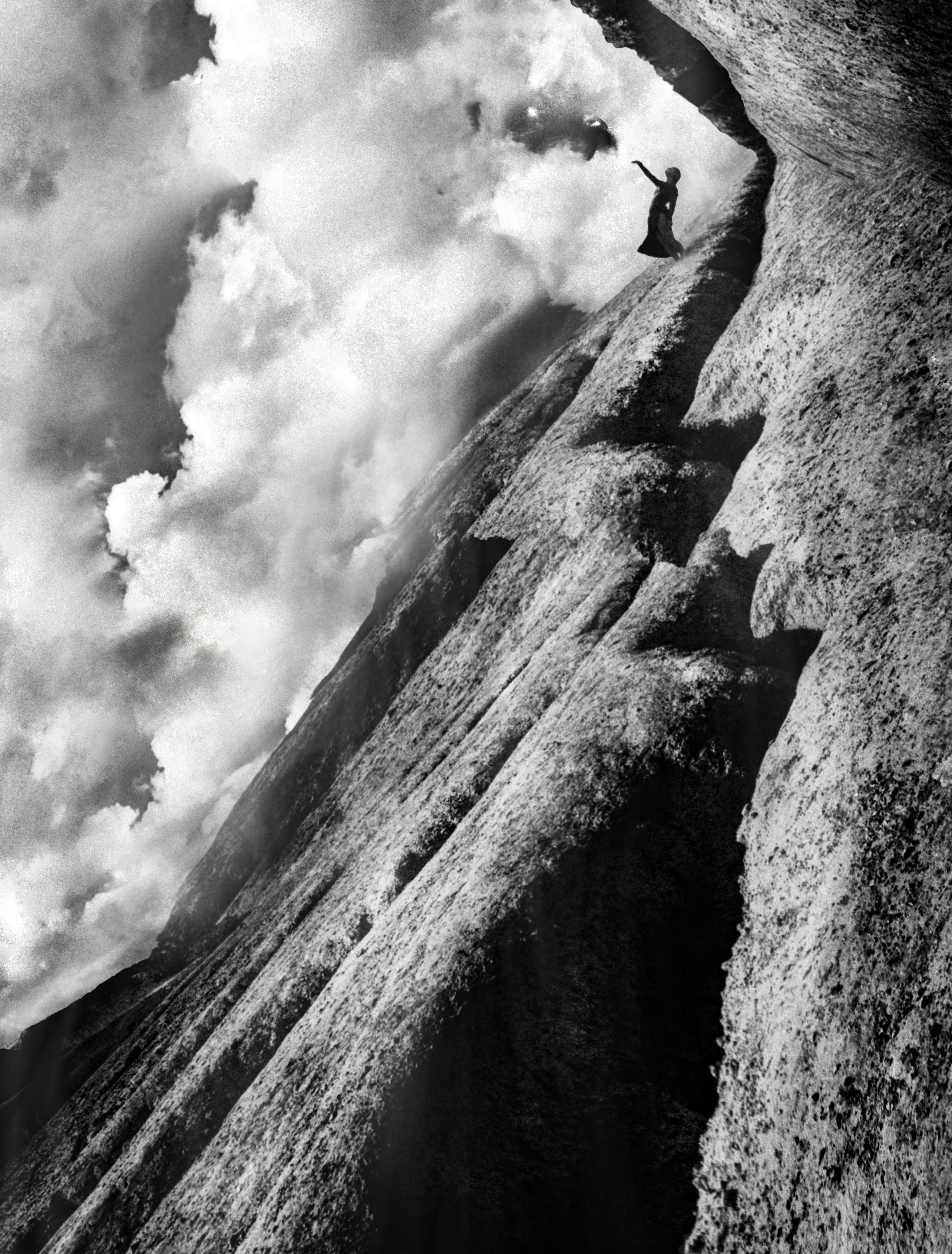 Lone figure standing on dark rocky cliff at twilight, vast dramatic sky, dim atmospheric low-key lighting, solitary and reflective