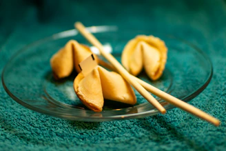 A plate of dumplings with chopsticks on a green cloth