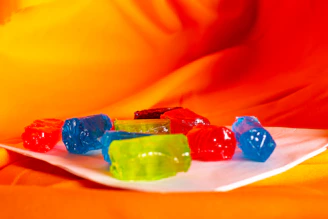 A plate of gummy bears sitting on a bed