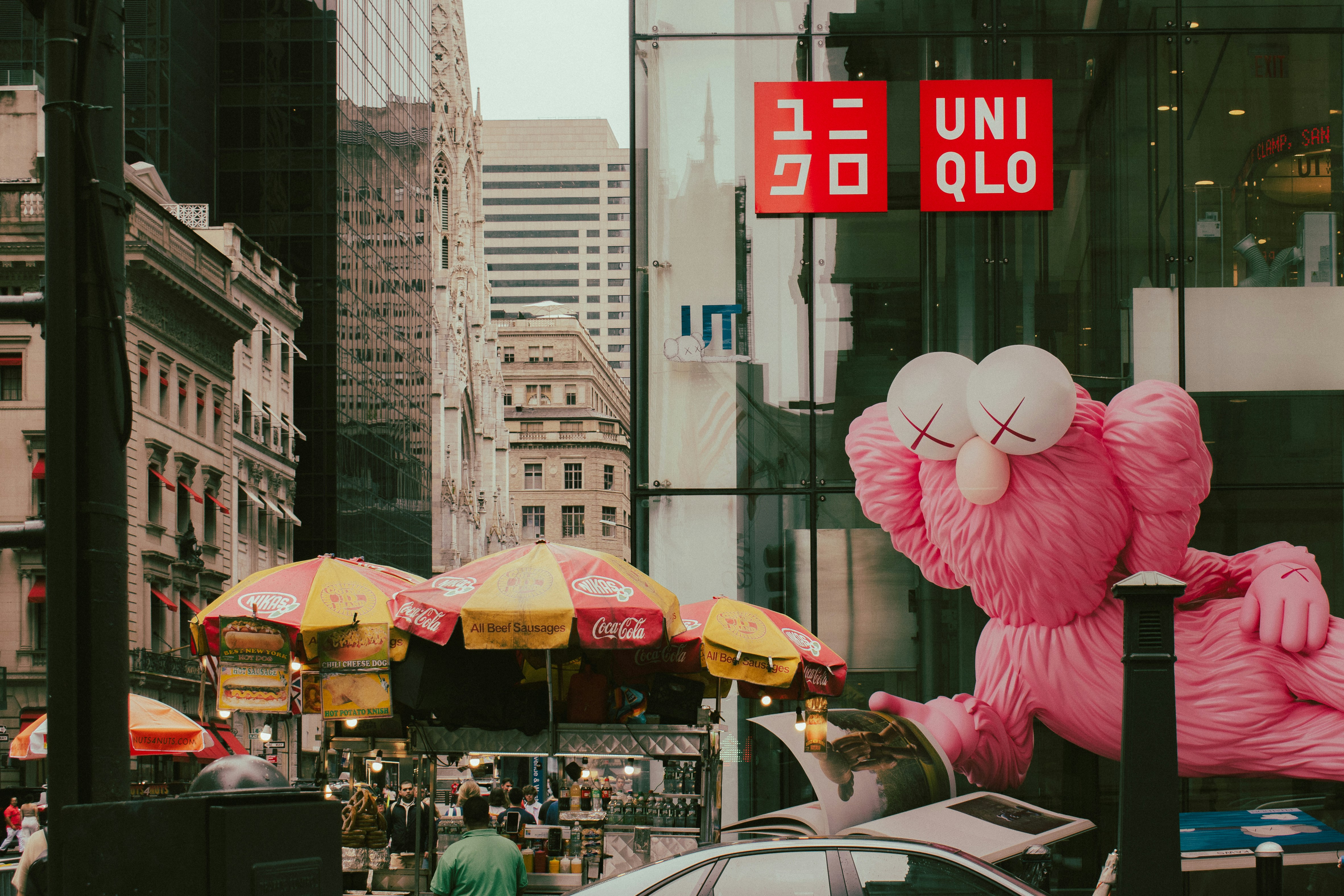 A large pink stuffed animal sitting on the side of a road