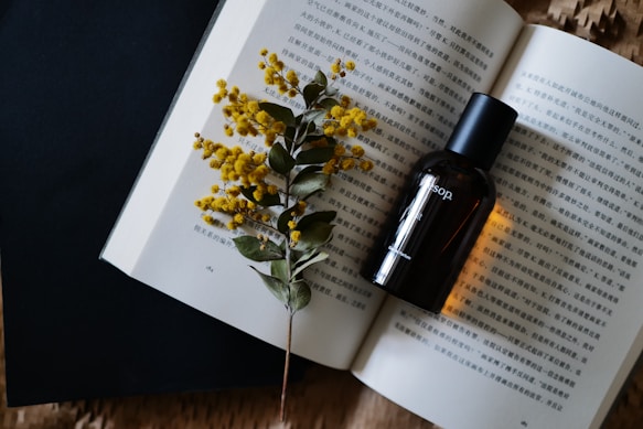 A bottle of essential oils sitting on top of an open book