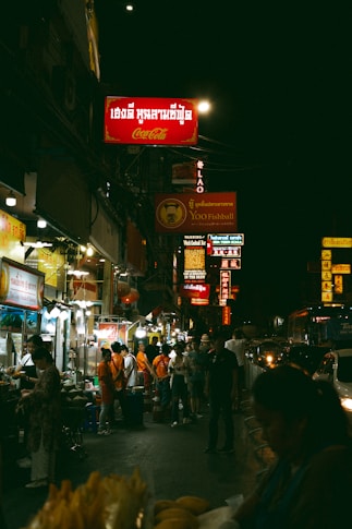 A crowded city street at night with a lot of people
