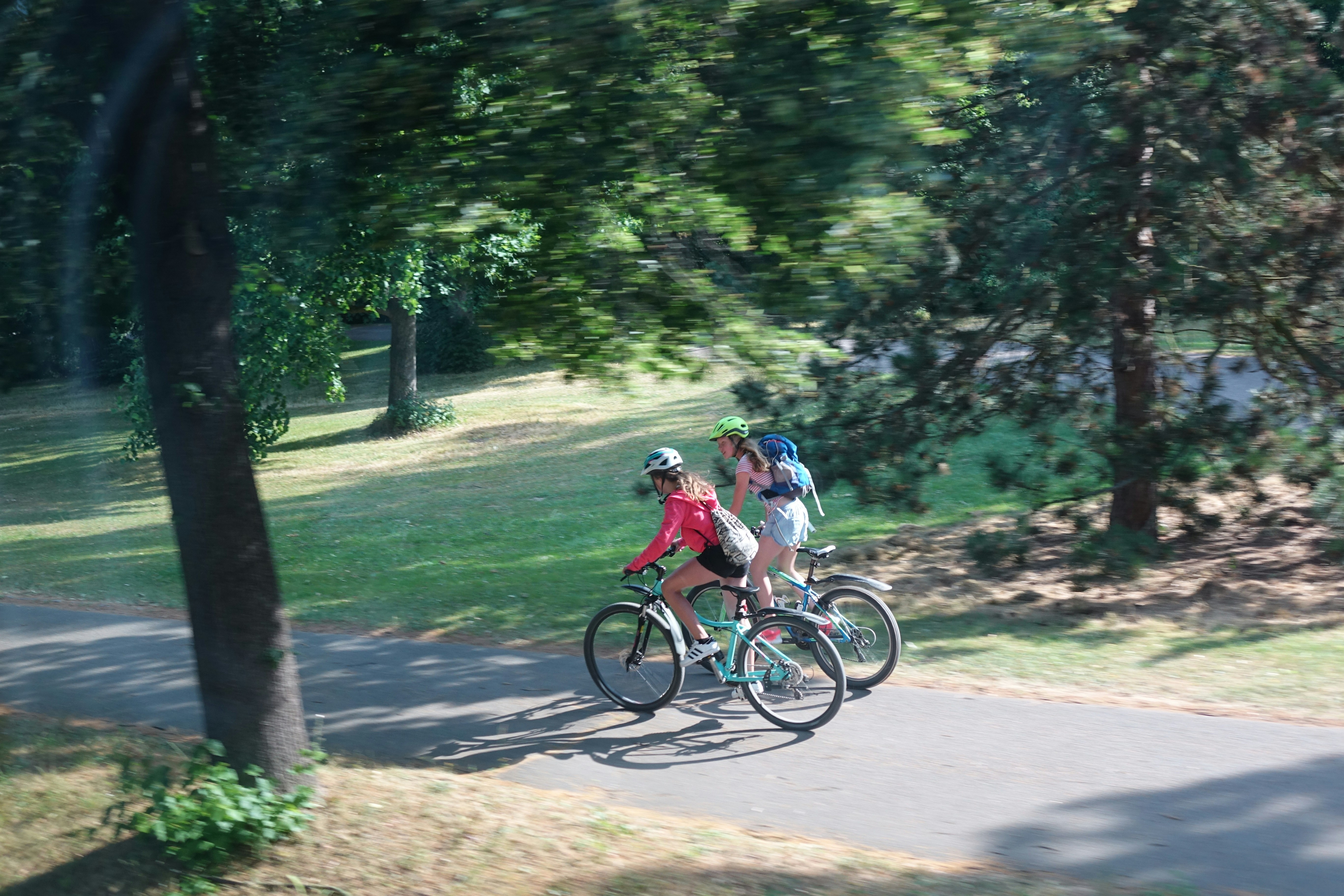 A group of people riding bikes down a road