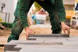 A man in a green shirt and some bricks