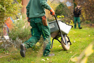 A man pulling a wheelbarrow with a wheel