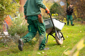 A man pulling a wheelbarrow with a wheel
