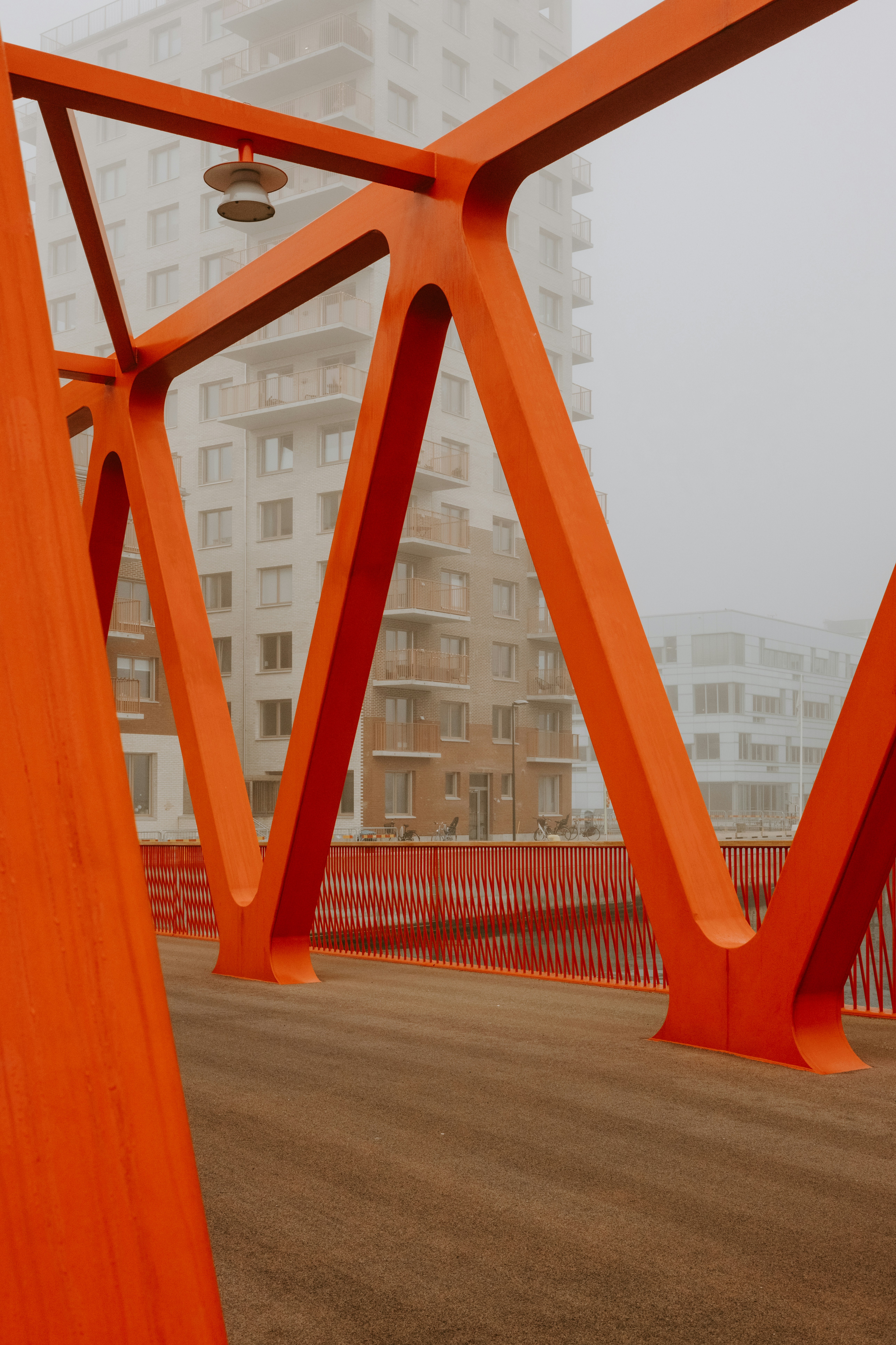 A large orange structure sitting on top of a dirt road