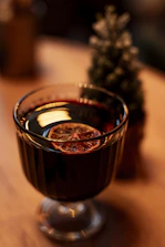 A glass filled with liquid sitting on top of a wooden table