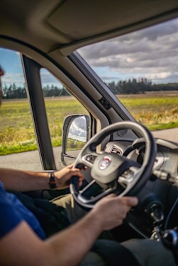 A man driving a car down a rural road