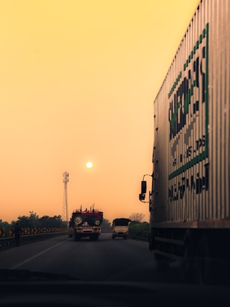 A truck driving down a highway next to a traffic light