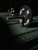 A row of black barbells in a dark gym