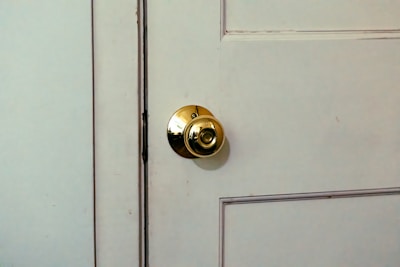 A close up of a door handle on a white door