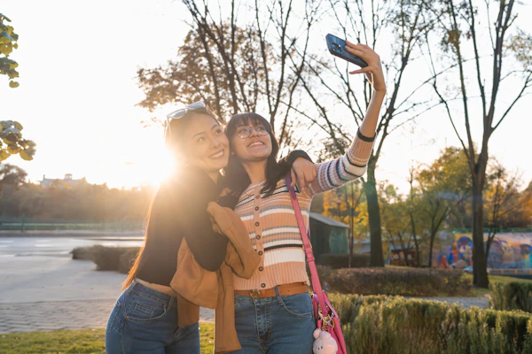 Two women taking a picture with a cell phone