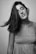 A black and white photo of a woman with her hair blowing in the wind