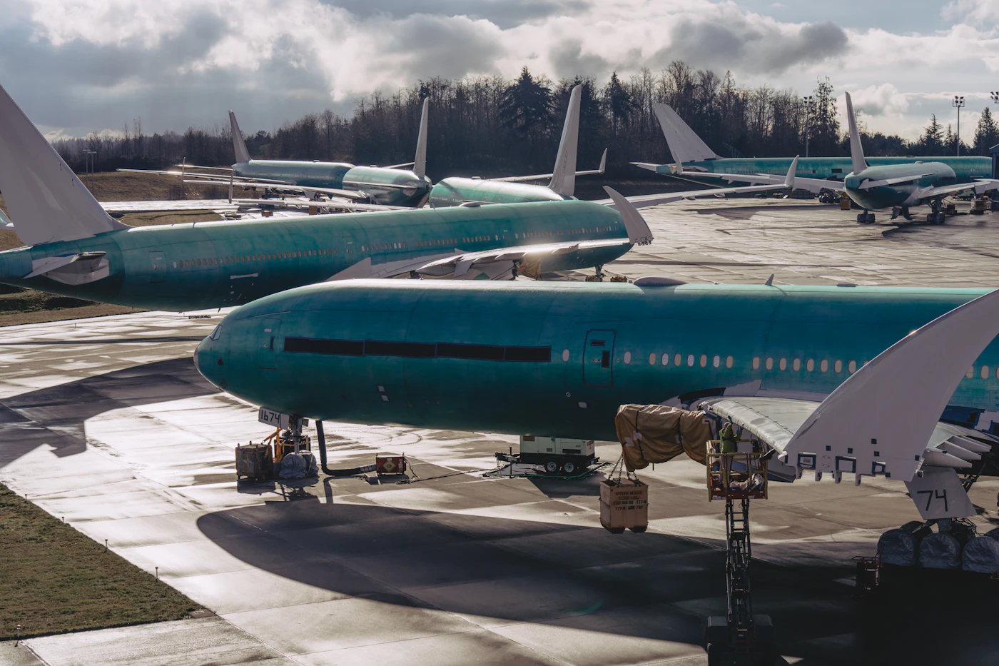 A group of passenger airplanes parked on an airport tarmac