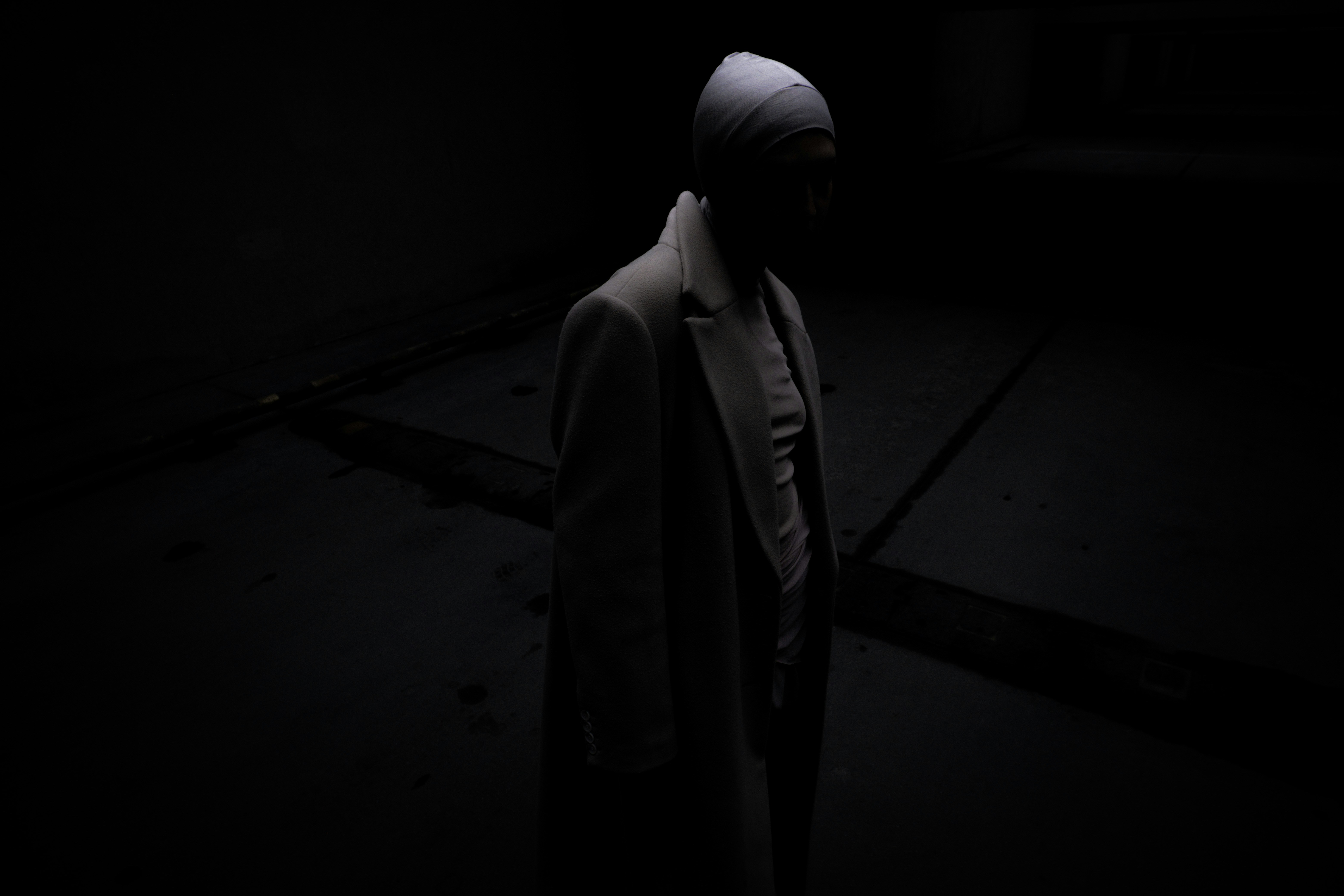 A person in a dark room with a hood on
