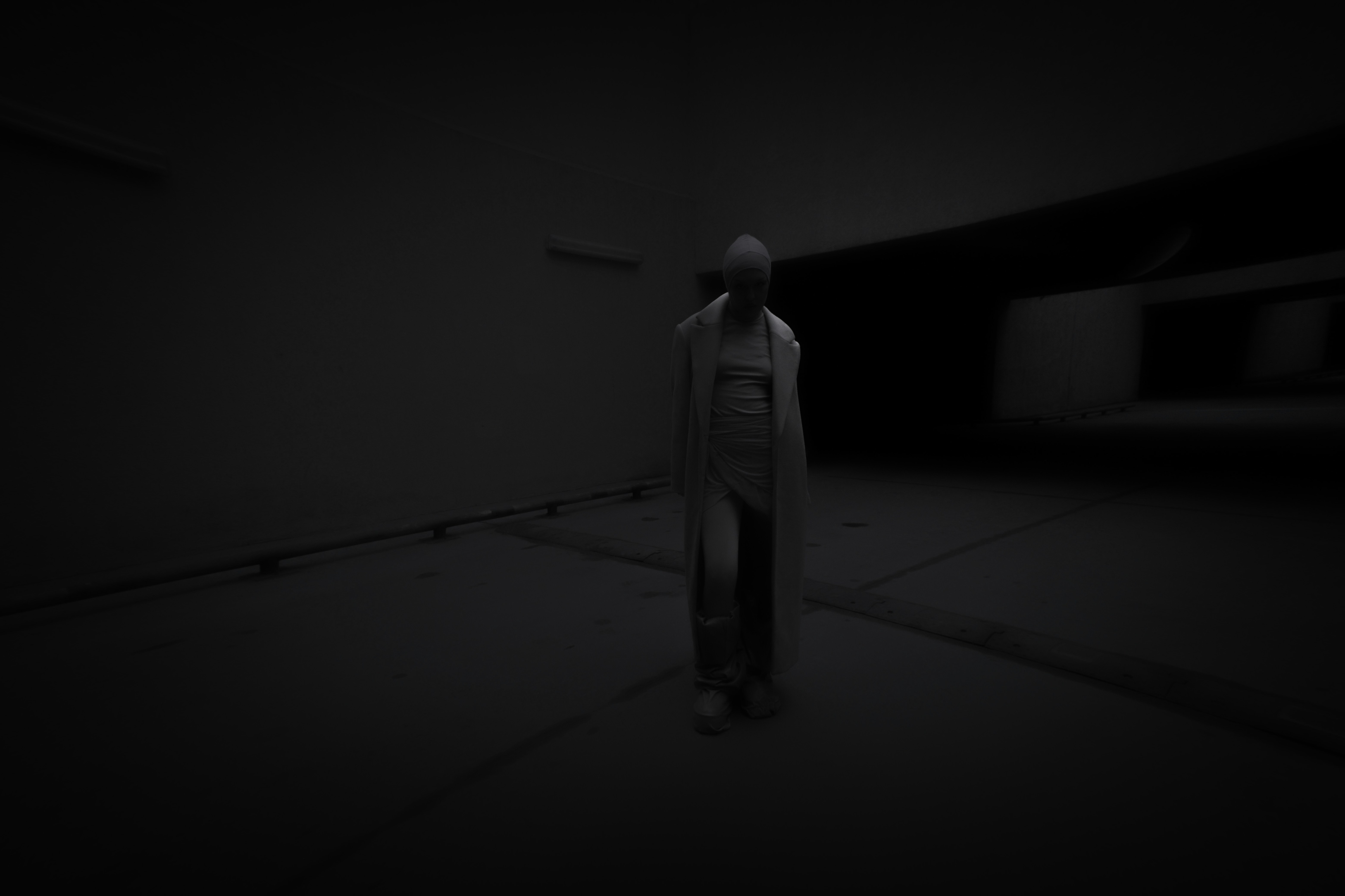 A person standing alone in a dark room