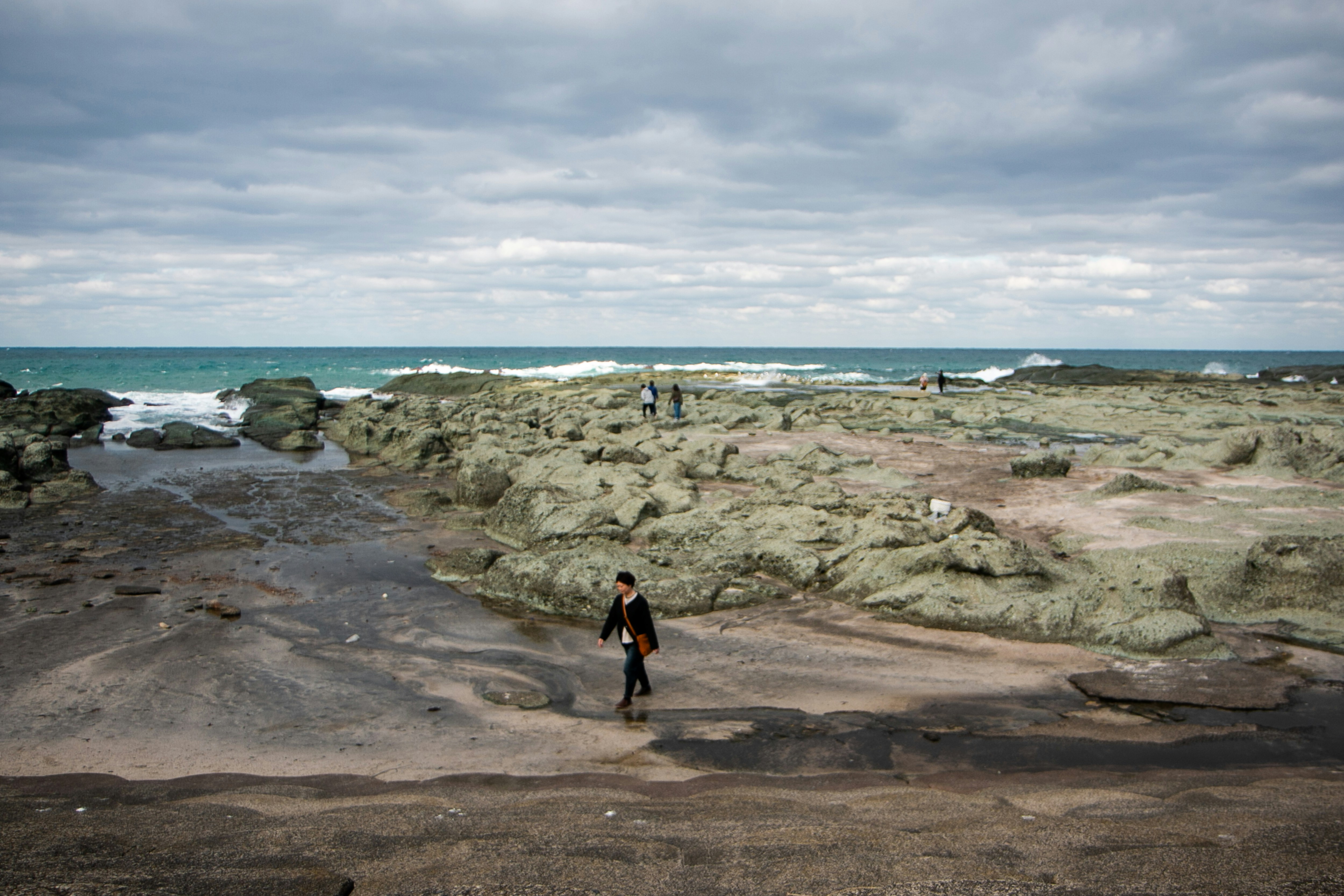 A person walking on a beach near the ocean