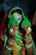 A woman dressed in a green and red outfit holding a green leaf