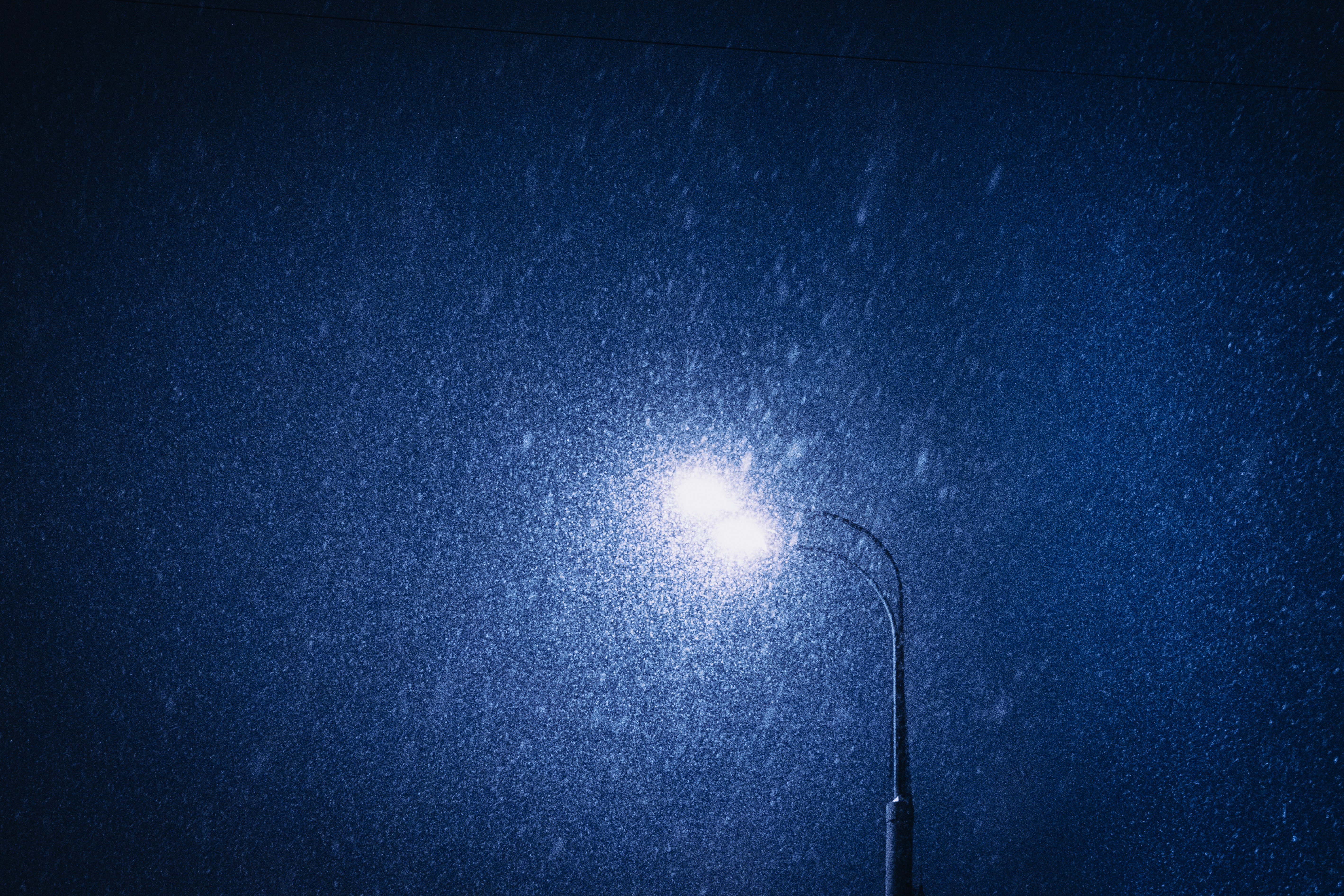 A street light in the rain at night