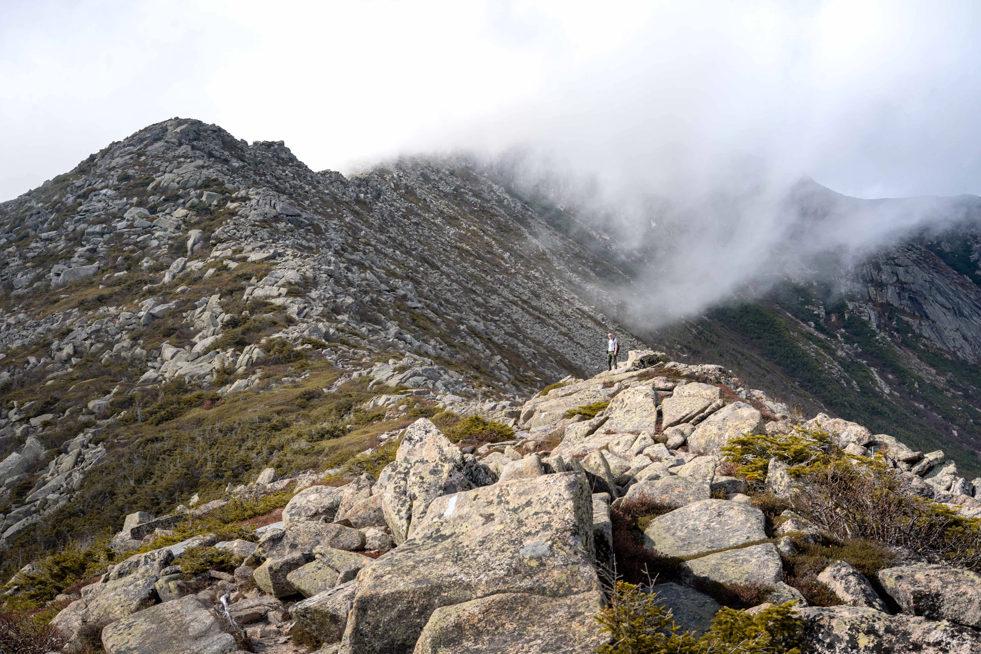 A person standing on top of a rocky mountain