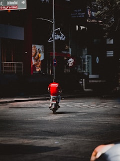 A person riding a motorcycle down a street at night