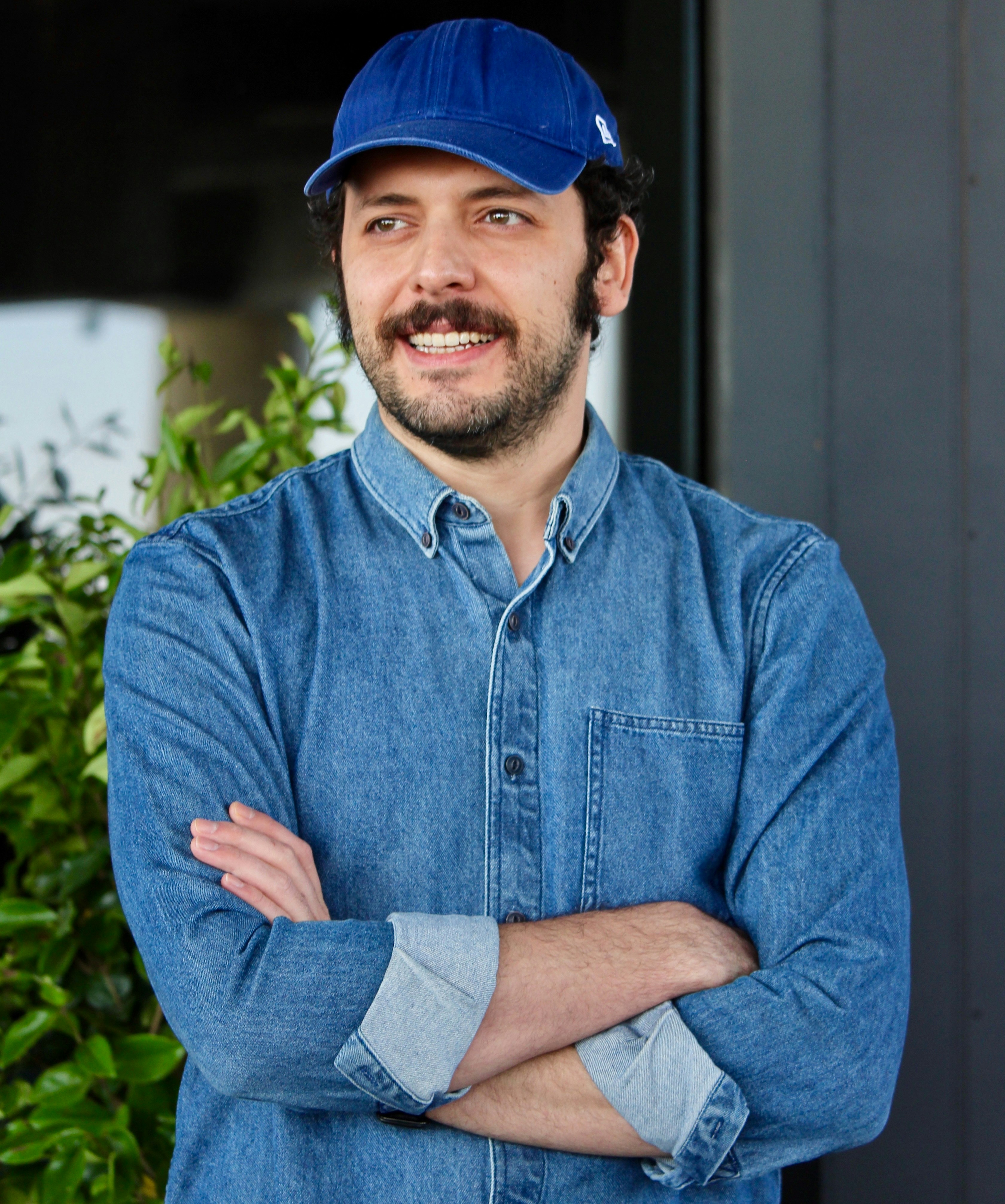 A man wearing a blue shirt and a blue hat