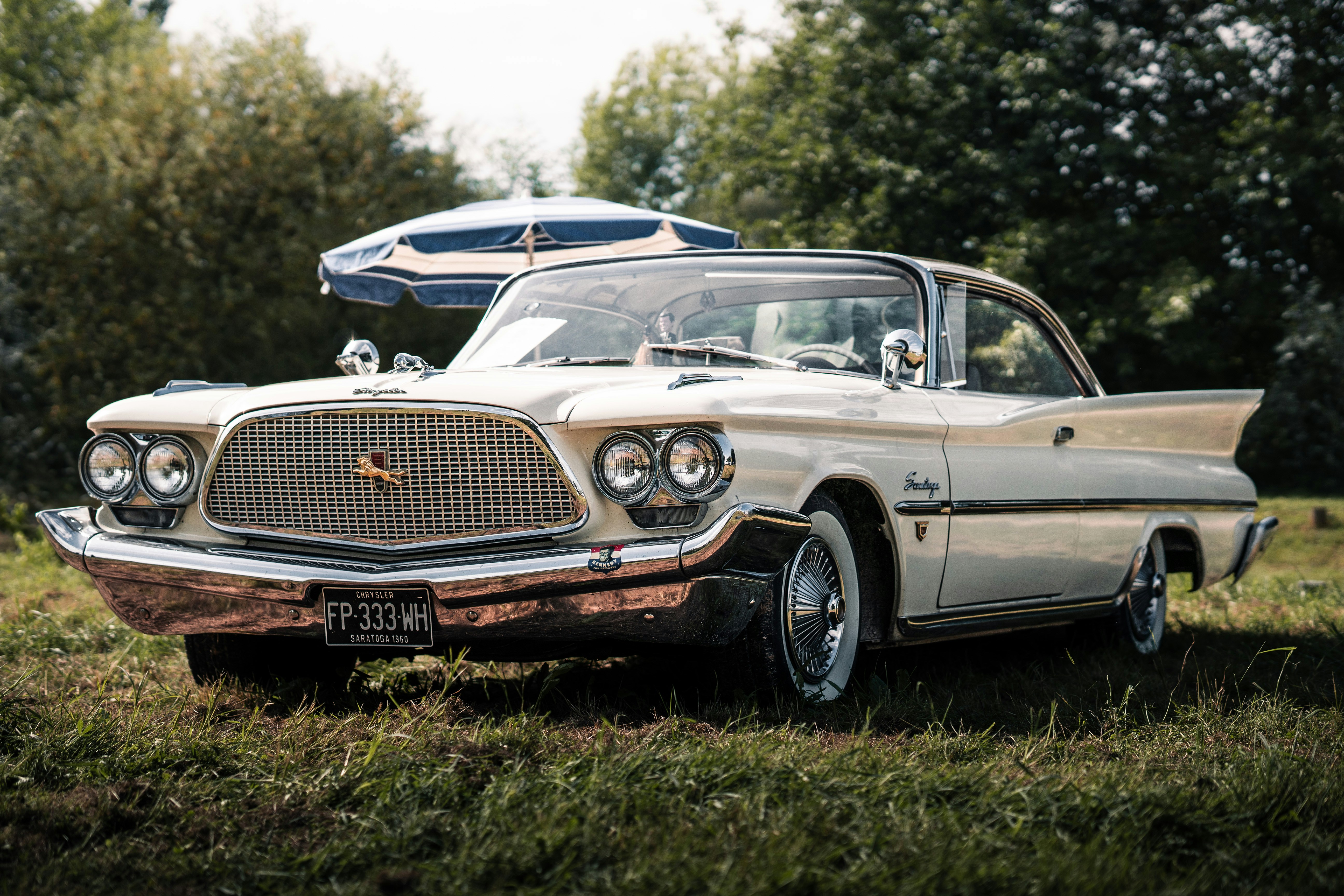 An old car is parked in a field