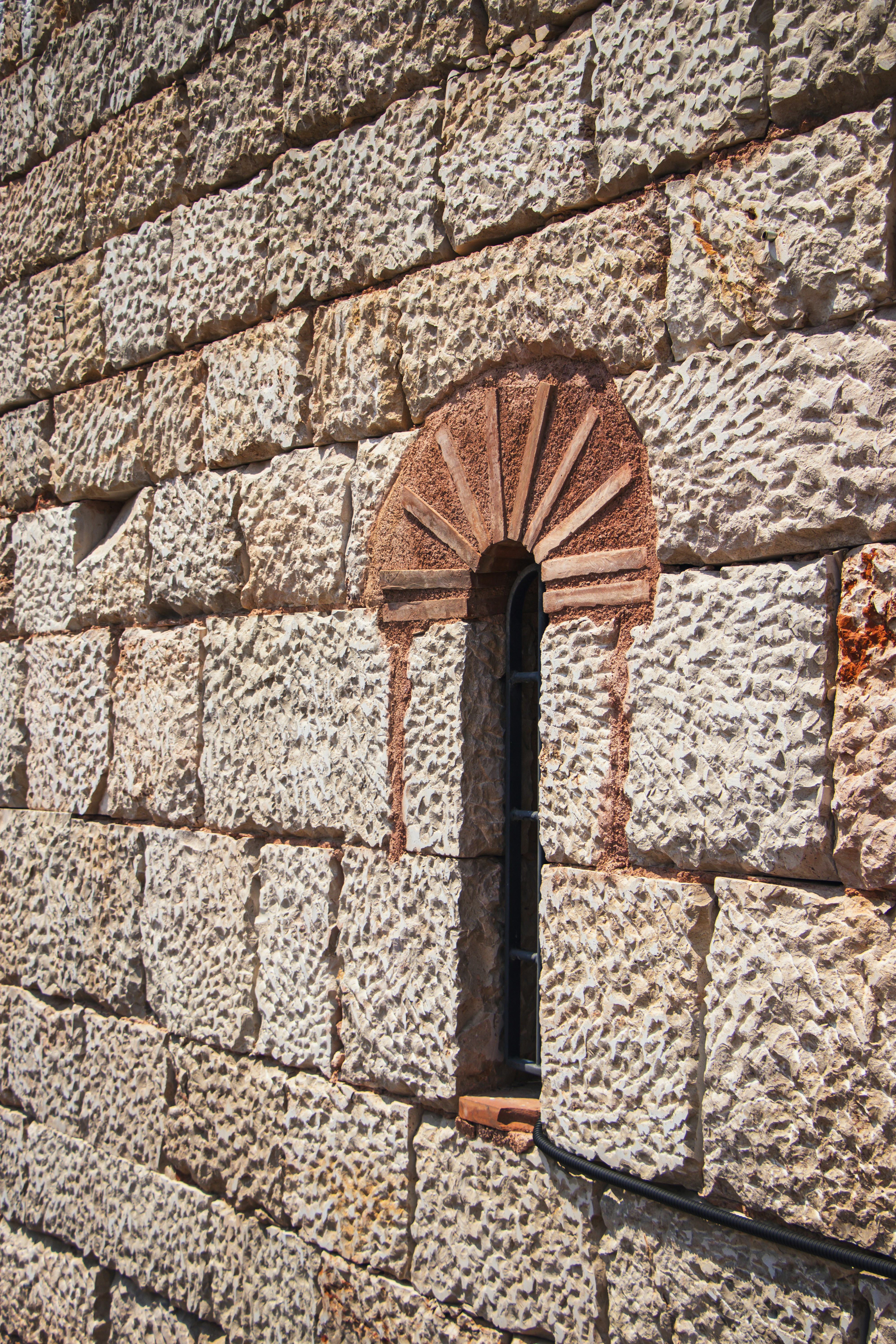 A brick wall with a window in the middle of it
