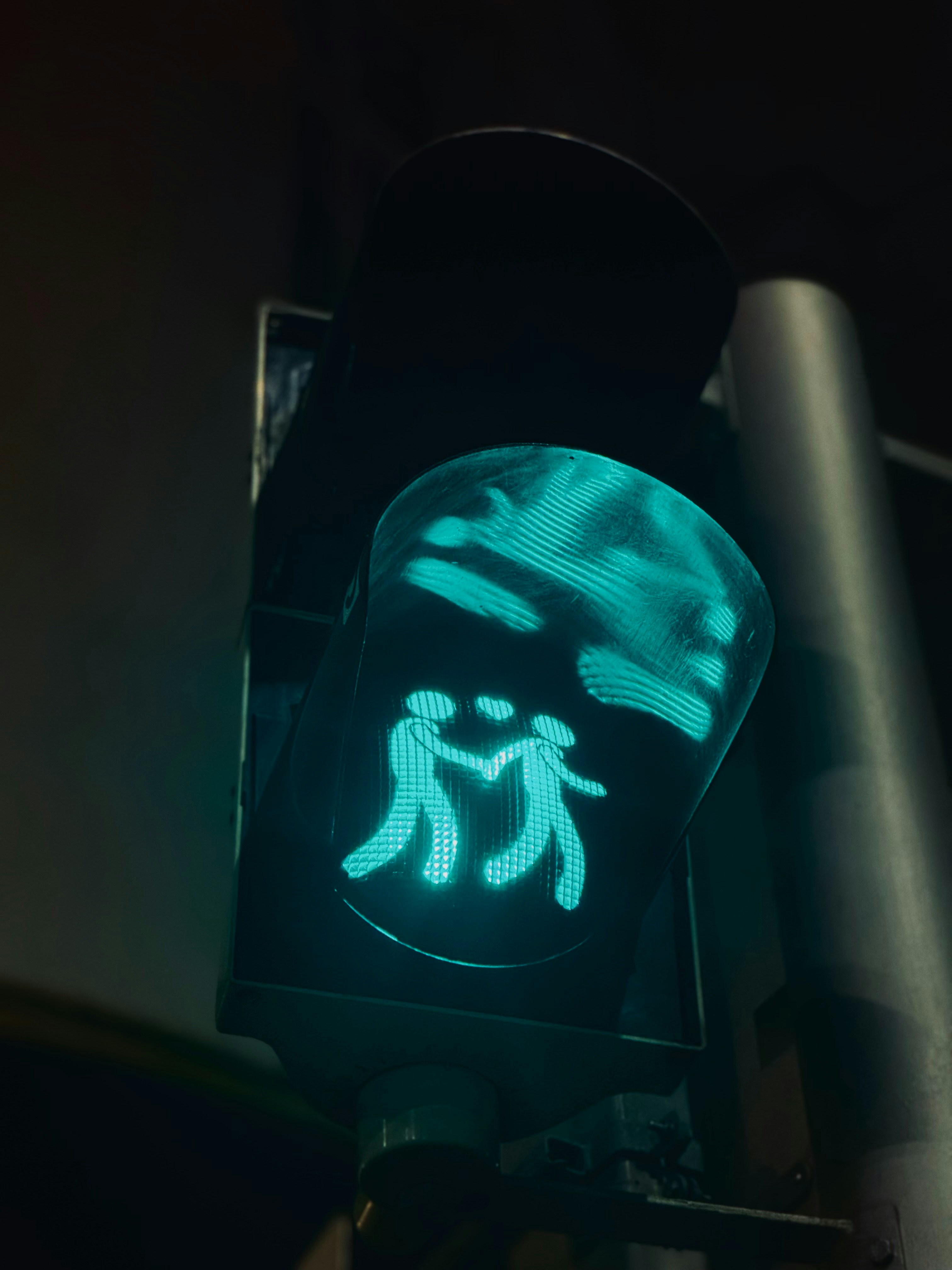 A green traffic light with a picture of a man and a woman on it